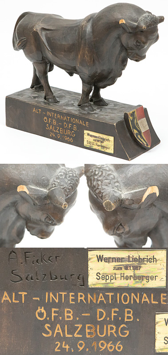 Holzstier Geschenk Herbeger an Liebrich  | Handgeschnitzer Holzstier mit farbigen Salzburger Wappen mit der Inschrift "Alt - Internationale ÖFB - DFB Salzburg 24.9.1966". Signiert "A.Ficker, Salzburg". Mit aufgesetzter vergoldeter, gravierter Plakette (6x3 cm) "Werner Liebrich zum 18.1.1967. SEPP HERBERGER". Diese Figur erhielt erhielt Sepp Herberger als Trainer der DFB Alt - Internationalen mit Werner Liebrich als Ehrengeschenk anläßlich des Spieles am 24.9.1966 vom ÖFB. Sepp Herberger hat diese Trophae mit einer Plakette veredelt und Werner Liebrich zum 40.Geburtstag einige Monate später geschenkt!. 25,5x26x10 cm Unikat!