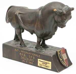 Holzstier Geschenk Herbeger an Liebrich  | Handgeschnitzer Holzstier mit farbigen Salzburger Wappen mit der Inschrift "Alt - Internationale ÖFB - DFB Salzburg 24.9.1966". Signiert "A.Ficker, Salzburg". Mit aufgesetzter vergoldeter, gravierter Plakette (6x3 cm) "Werner Liebrich zum 18.1.1967. SEPP HERBERGER". Diese Figur erhielt erhielt Sepp Herberger als Trainer der DFB Alt - Internationalen mit Werner Liebrich als Ehrengeschenk anläßlich des Spieles am 24.9.1966 vom ÖFB. Sepp Herberger hat diese Trophae mit einer Plakette veredelt und Werner Liebrich zum 40.Geburtstag einige Monate später geschenkt!. 25,5x26x10 cm Unikat! - Bild 2