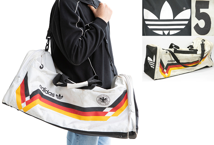 World cup 1990 Adidas Tasche  | Original Sporttasche von Matthias Herget von der Fußball - UEFA Euro 1988 mit der aufgedruckten Nummer "5" (Trikotrückennummer von Herget während der Euro 1988). Adidas mit dem DFB Logo und Desgin des DFB. 70x36x26 cm.