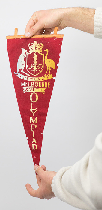 1)Souvenirwimpel OS1956  | Weiß bedruckter Souvenirwimpel von den Olympischen Spielen 1956 aus Filz. Mit der Aufschrift mit dem Aufdruck "Australia Melbounre. XVIt Olympiad". 43x18 cm