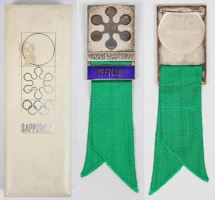 Teilnehmerabzeichen 1972  | Offizielles Teilnehmerabzeichen Sapporo 1972 „Official“. Bronze, versilbert. Schriftleiste violett emaliert. Mit grünem Seidenband, 14x3,8 cm. Mit original Box.