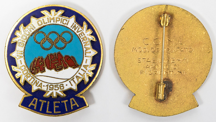 Olympic Winter Games 1956. Participation badge. - Official participation badge 1956. Olympic Winter Games Cortina d'Ampezzo 1956. With inscription "Atleta" (Athletes). Bronze, gold plated, multicolour enamelled, 4x3,5 cm. Original paper packaging with the print "Atleta". Edition of 1083 copies (Elbel, No. 1956-W-005). Condition: A