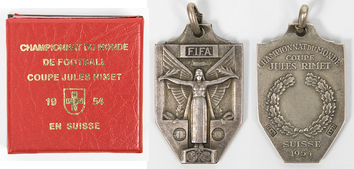 Siegermedaille WM1954  | Offizielle Siegermedaille der österreichischen Mannschaft für den 3.Platz bei der 5.Fußball-Weltmeisterschaft 1954 in der Schweiz. „Championat du Monde Coupe Jules Rimet Suisse 1954" Silber, gestempelt (925er Silber, 14,35 gr.). Hersteller: "PEKA", 3,6x2,3 cm. Dabei eine Box im Stile der original Verpackungen von 1954.