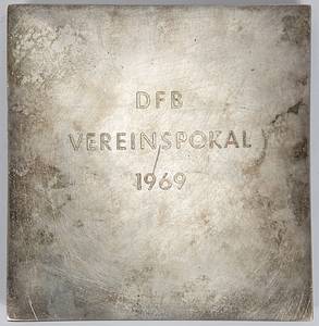  - Winner's medal belonging to Reinhard "Stan" Libuda, awarded as a player for Schalke 04 for finishing in 2nd place in the 1969 DFB-Pokal following the final match held on June 14, 1969, in Frankfurt (Bayern Munich 2–1 Schalke 04). Heavy bronze plaque (1.4 kg, silver-plated) inscribed "DFB Vereinspokal 1969." 12.5 x 12.5 cm. Housed in its original presentation case. --The players of Bayern Munich received the same medal, albeit gold-plated. Only 22 silver-plated medals were issued to the players of Schalke 04. --This item comes directly from the estate of Reinhard "Stan" Libuda (1943–1996). 3rd Place – 1970 FIFA World Cup. 26 Senior International Caps (DFB). 289 Bundesliga Matches (Schalke 04 + Borussia Dortmund). European Cup Winner 1966 (with Dortmund). DFB Cup Winner 1972 (with Schalke). German Vice-Champion 1966 (BVB) + 1972 (Schalke). The item is supplied with a Certificate of Authenticity (COA)! Condition: A- - Bild 3