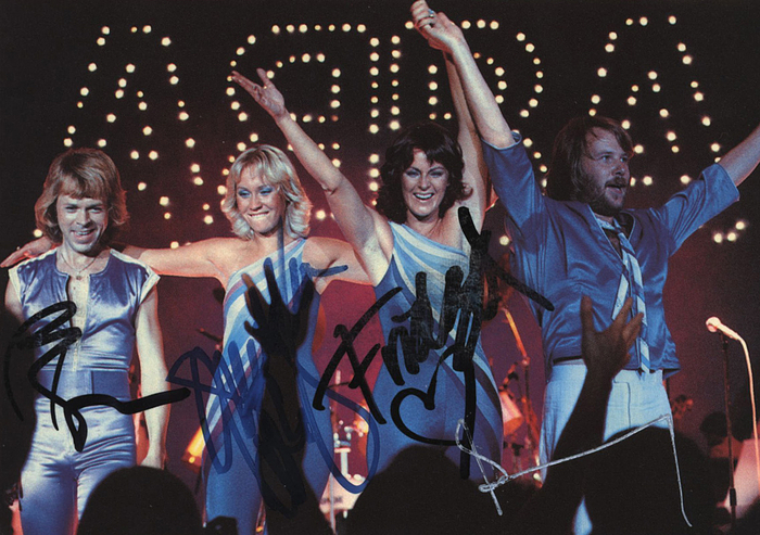 Abba  | Farbautogrammkarte von der schwedischen Popgruppe ABBA. Mit den original Signaturen von Agnetha Fältskog, Björn Ulvaeus, Benny Andersson und Anni-Frid Lyngstad. 15x10,5cm. Dabei ein Echtheitszertifikat von "VMS".