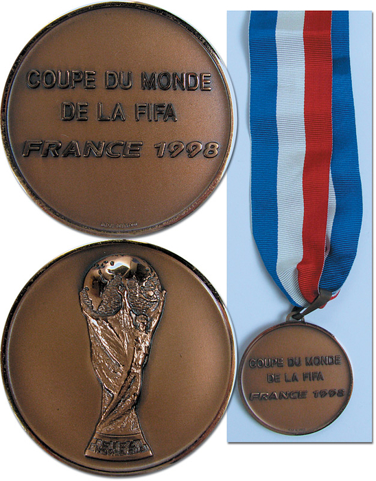 Siegermedaille WM1998  | Offizielle Siegermedaille der kroatischen Mannschaft für den 3.Platz bei der Fußball-Weltmeisterschaft 1998 in Frankreich. Coupe du monde de la FIFA France 1998“ Bronze an original, dreifarbigem Seidenband. Hersteller: Bertoni. 5 cm.