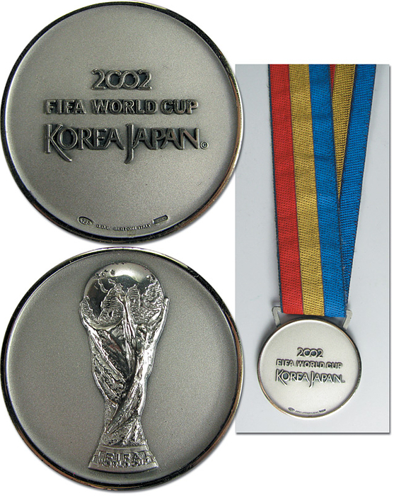 FIFA World Cup 2002. Winner medal Germany - FIFA World Cup 2002. Winner medal Germany: Official winner medal for the German team who were runner-up World Champions at the World Cup in Korea and Japan 2002. "2002 FIFA World Cup Korea Japan“ Hallmarked silver (925) on original three-coloured silk ribbon. Made by Bertoni. 5 cm. This medal was awarded to all German players and coaches at the winner ceremony after the final Brazil - Germany (2:0) on 30th June 2002. The Brazilian team got the same medals, yet theirs are gold. A total of 30 medals was presented to the German team. Absolutely rare. Extra fine. In orginal case with attached silver FIFA emblem, 12.5 x 12.5 x 3.2 cm. Medal comes from the collection of a senior official-. Condition: A-