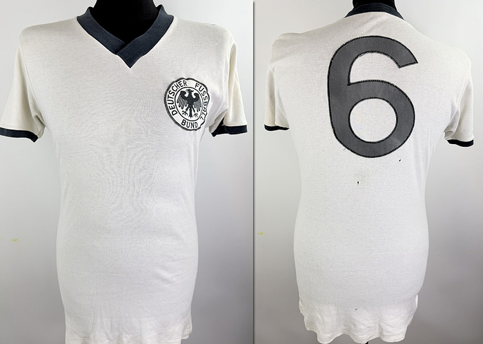  - Original match-worn DFB player shirt, number 6. Worn by Wolfgang Overath during the international match between Germany and Brazil on June 16, 1973, in Berlin. This specific jersey model in this particular variant was worn only during this single match. The shirt originates from the collection of a former DFB kit manager. Status: ABA. Short-sleeve jersey; Size L; Sewn-on DFB eagle; Sewn-on back number; 100% cotton. Condition: A-