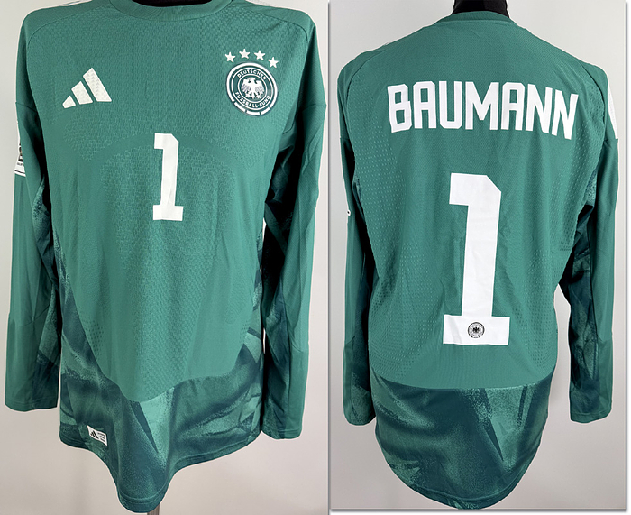 - Original match-issued DFB player shirt with the number 1, worn by Oliver Baumann. Prepared for the 2026 World Cup qualifier against Slovakia on November 17, 2025, in Leipzig. The jersey comes from the collection of a former DFB employee. Status: AAB. Long-sleeved shirt; size 8; DFB logo, rubberized Adidas logo, rubberized player number and name; rubberized 2026 World Cup qualifier patch; flocked Hearts and Foundation patches; Adidas Climacool+; 100% polyester; made in Vietnam. Condition: A